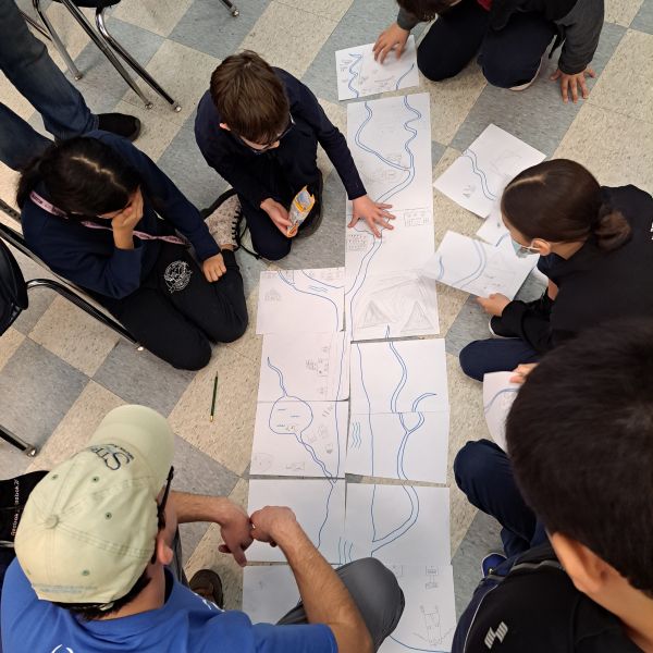 Students look at macroinvertebrates in bucket