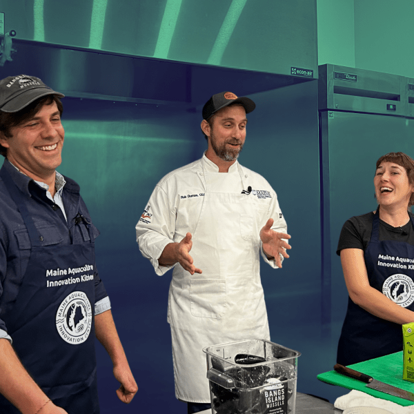 Chef Rob Dumas (center) cracks a joke that has Matt Moretti of Bangs Island Mussels, and Emily of MAIC, laughing while learning to cook Mussels Gratin
