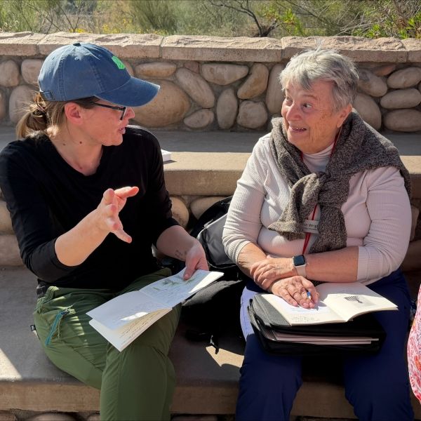 Staci Grady (HS educator) and Bonnie Wright (Mirabella resident) discussing developing a sense of place and belonging through nature journaling and mindfulness practices sitting on a stone wall