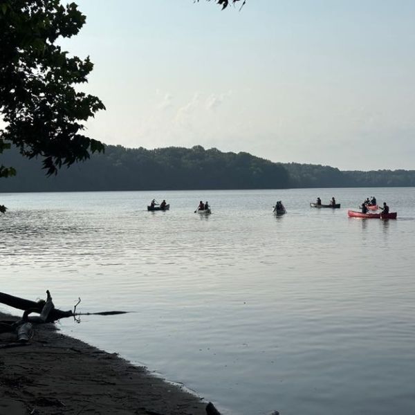 A landscape shot of a river with kayakers.