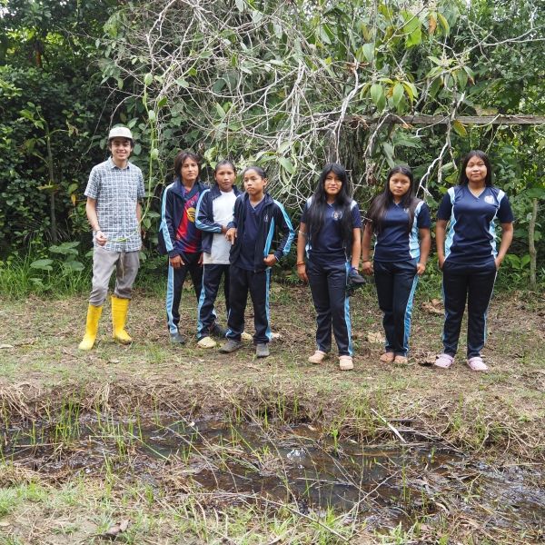 Students stand with their instructor near a vanilla nursery.