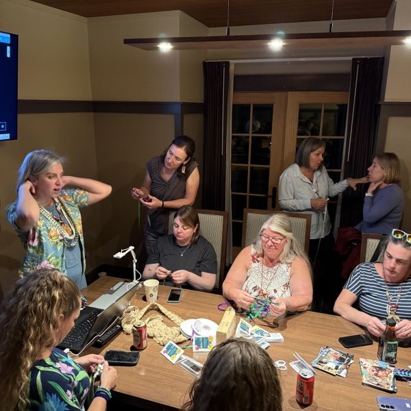 Group of educators sitting around a table conducting a lei building workshop.