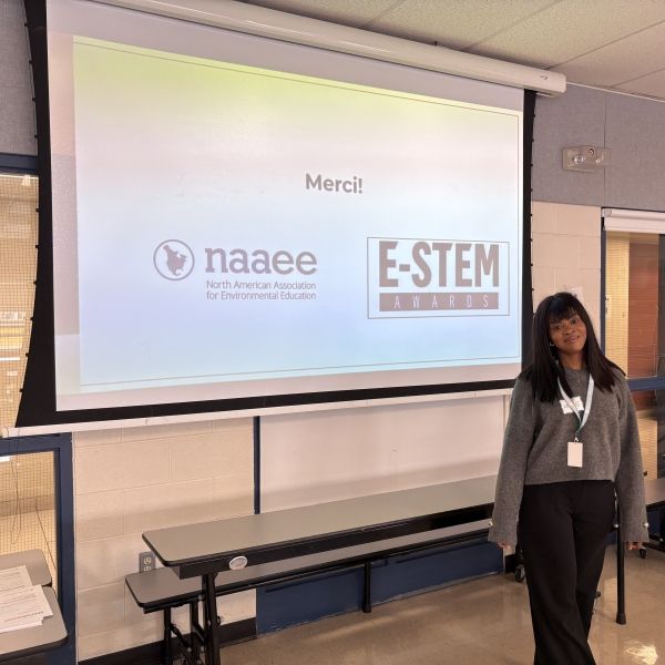 Francophone facilitator acknowledging NAAEE and E-STEM at the end of the Youth Power: Smart Schools workshop